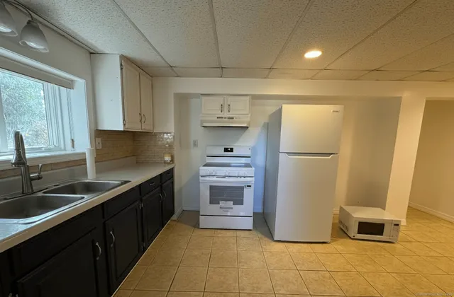 a kitchen with a sink a refrigerator and cabinets
