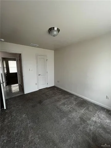 an empty room with a fireplace and wooden floor