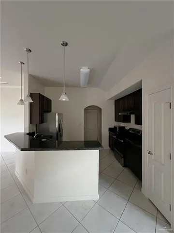 a kitchen with stainless steel appliances kitchen island granite countertop a sink and a stove