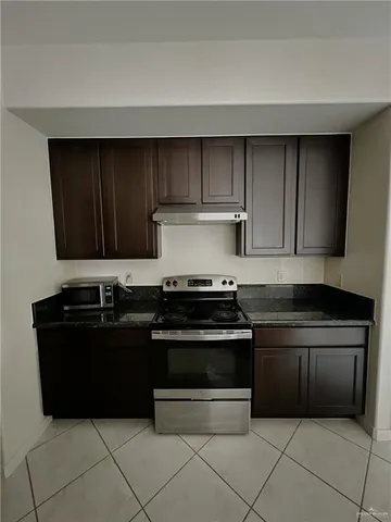a kitchen with granite countertop a stove and a refrigerator