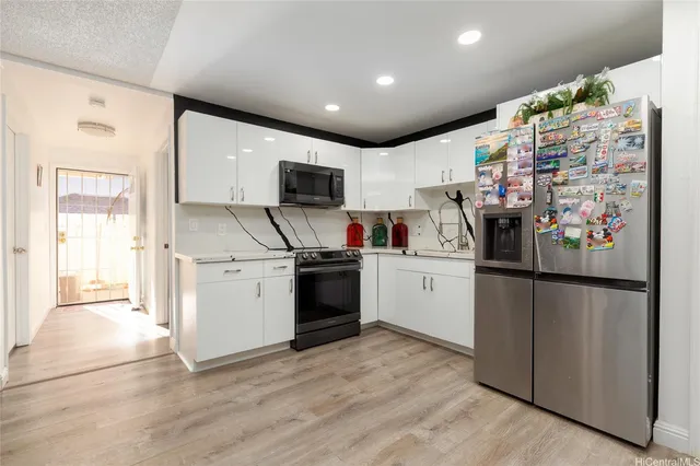 a kitchen with stainless steel appliances a refrigerator sink and microwave
