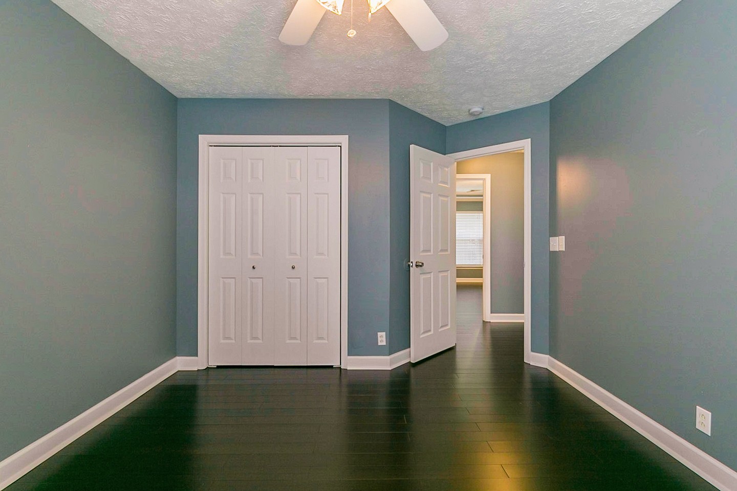 409 Ashby Place Antioch, TN 37013 - Photo 19 of 26 an empty room with wooden floor and windows with curtains