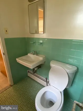 a bathroom with a toilet sink and mirror