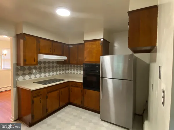 a kitchen with a sink a refrigerator and cabinets