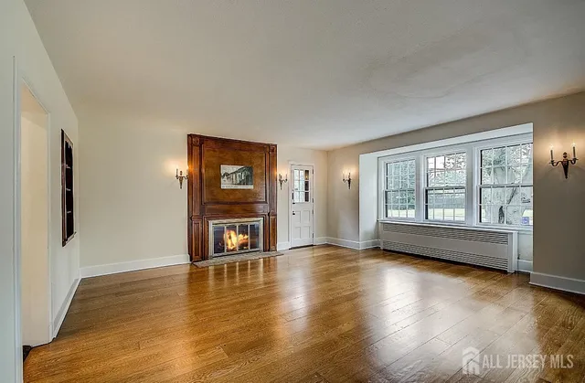 a view of an empty room with glass door and wooden floor