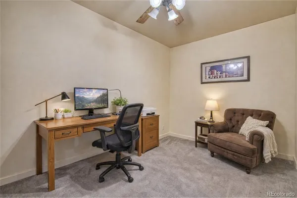 a livingroom with workspace and a couch