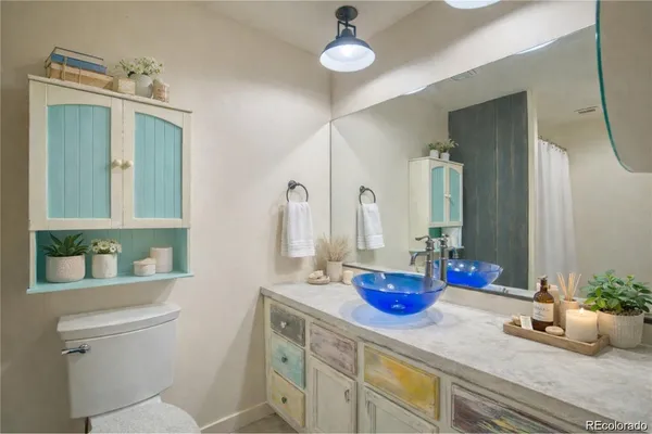 a bathroom with a granite countertop sink a toilet and mirror