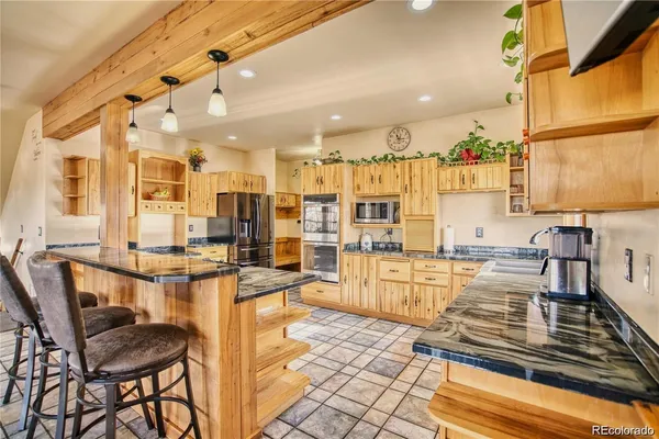 a kitchen with stainless steel appliances kitchen island granite countertop a table and chairs in it