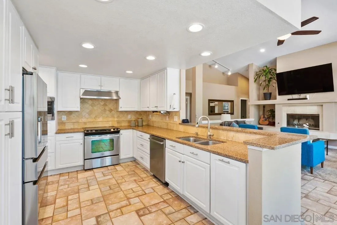 15735 Riparian Road Poway, CA 92064 - Photo 14 of 53 a large kitchen with stainless steel appliances kitchen island granite countertop a sink and a stove