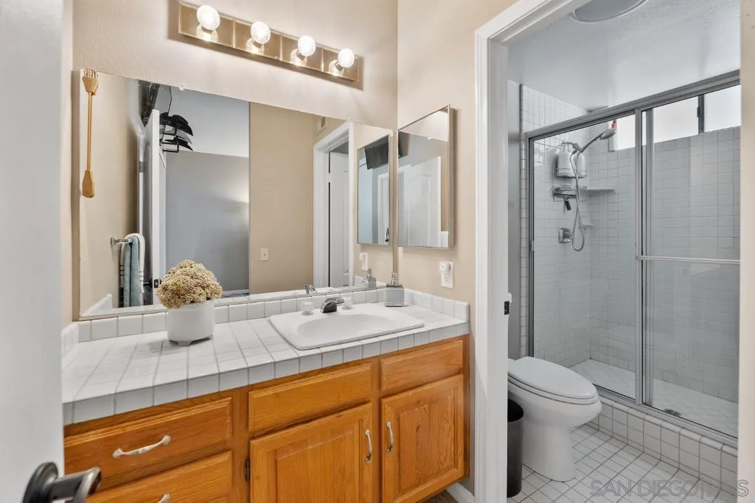 15735 Riparian Road Poway, CA 92064 - Photo 38 of 53 a bathroom with a granite countertop sink a toilet and shower