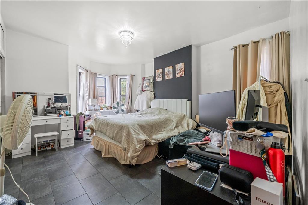 904 Avenue C Brooklyn, NY 11218 - Photo 11 of 13 a bedroom with a bed and wooden floor