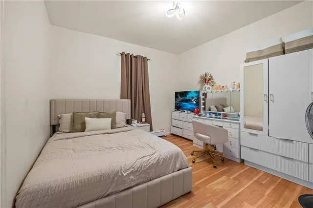 a bedroom with a bed table closet and a flat screen tv