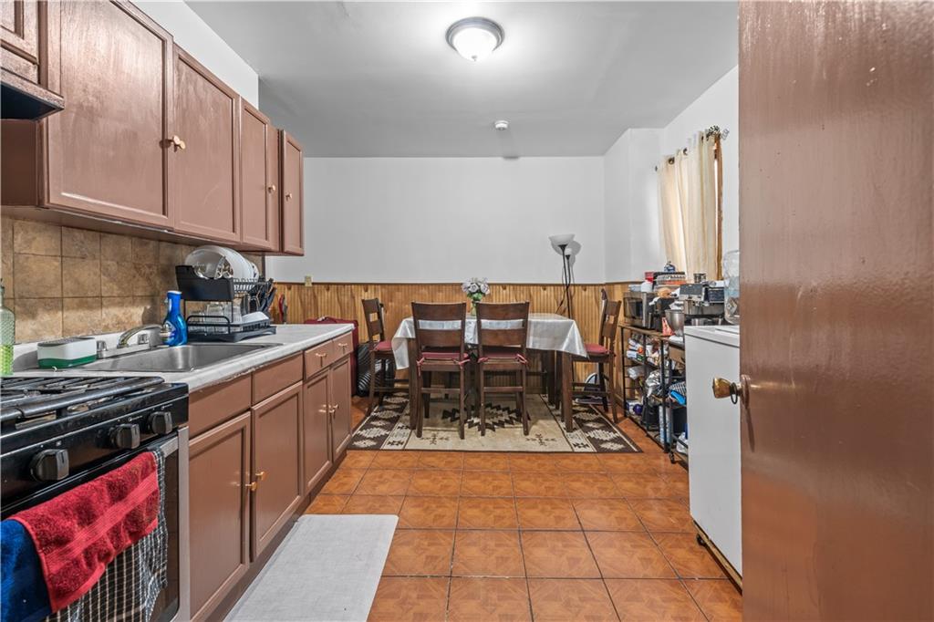 904 Avenue C Brooklyn, NY 11218 - Photo 7 of 13 a kitchen with stainless steel appliances a stove a sink and cabinets
