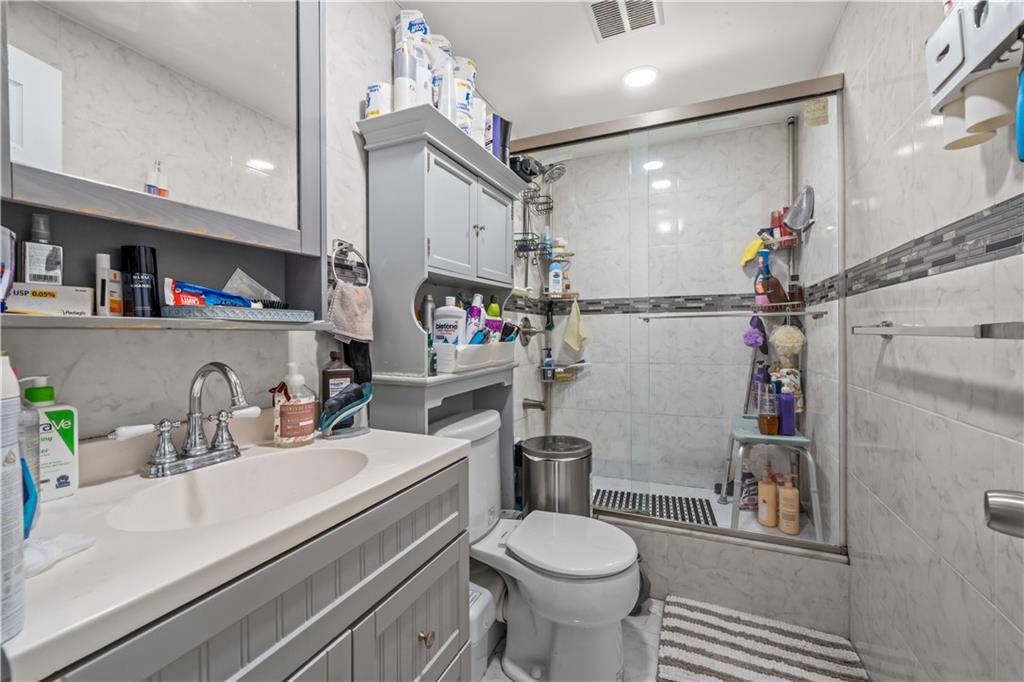 904 Avenue C Brooklyn, NY 11218 - Photo 9 of 13 a bathroom with a sink a toilet and a mirror