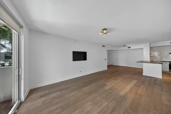 a kitchen with granite countertop a refrigerator oven a sink and white cabinets