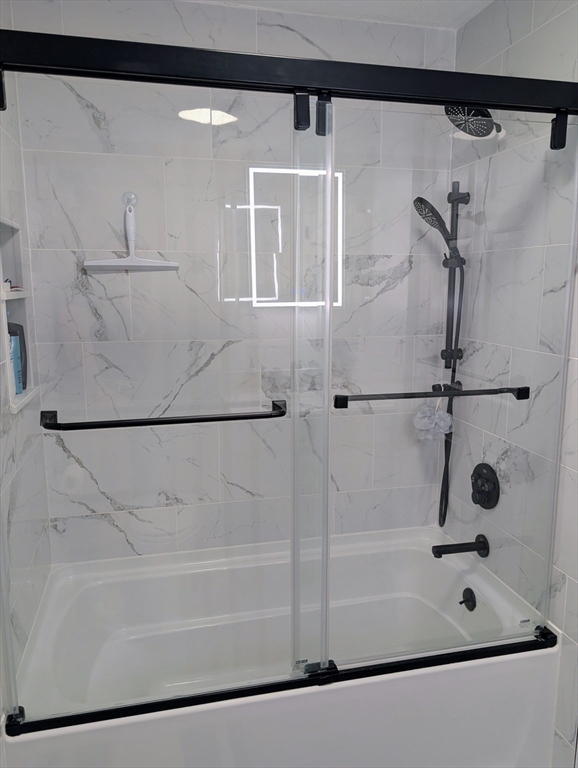 24 Charles Street, Unit 10 Douglas, MA 01516 - Photo 21 of 35 a bathroom with a shower and a bath tub