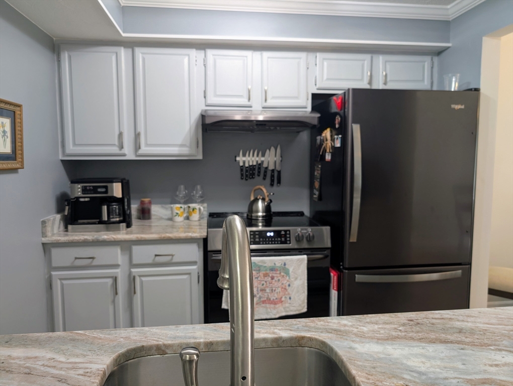 24 Charles Street, Unit 10 Douglas, MA 01516 - Photo 4 of 35 a kitchen with stainless steel appliances granite countertop a refrigerator and a stove