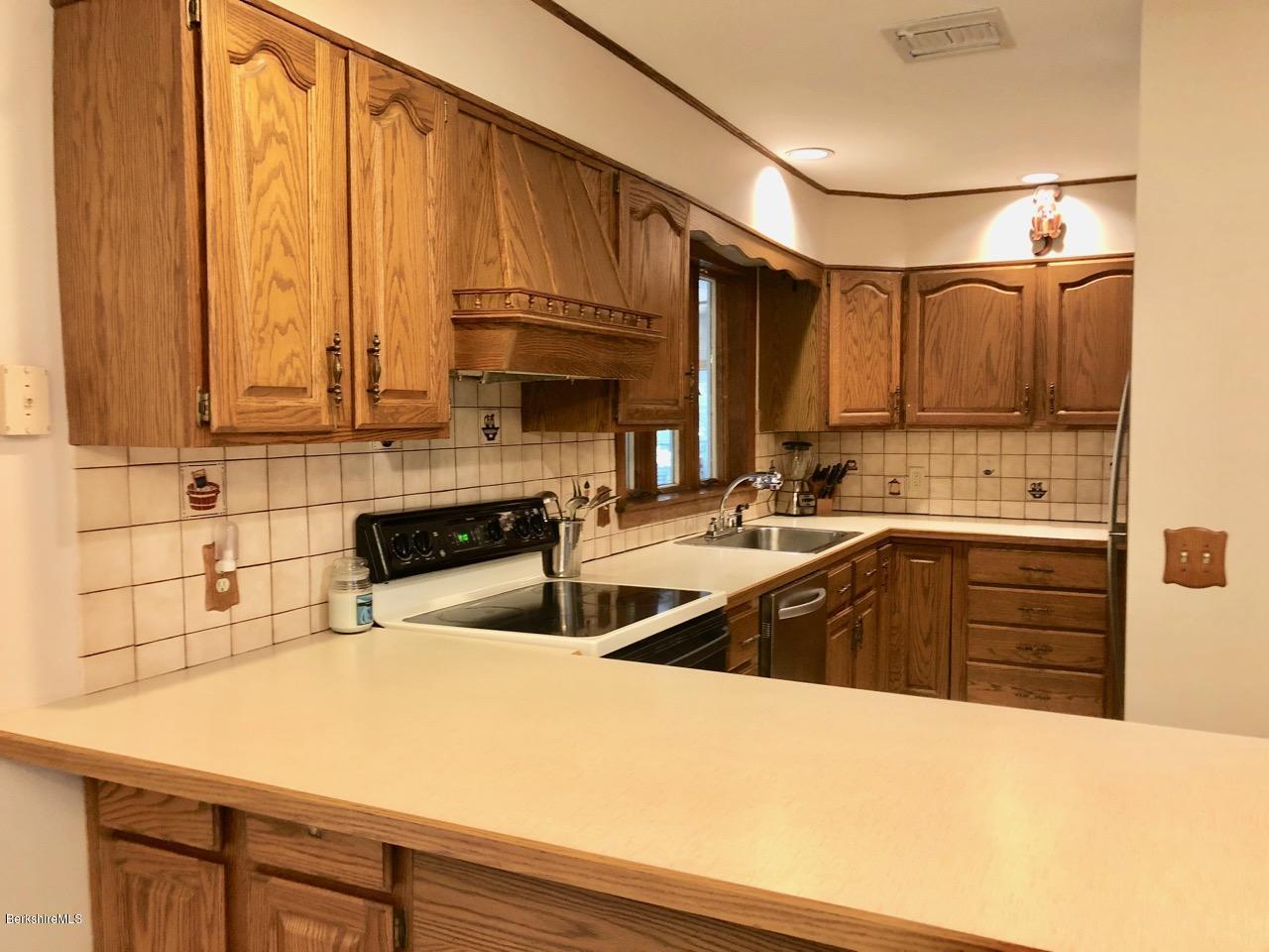 83 Pine Knoll Road Lenox, MA 01240 - Photo 11 of 32 a kitchen with a sink a stove and cabinets