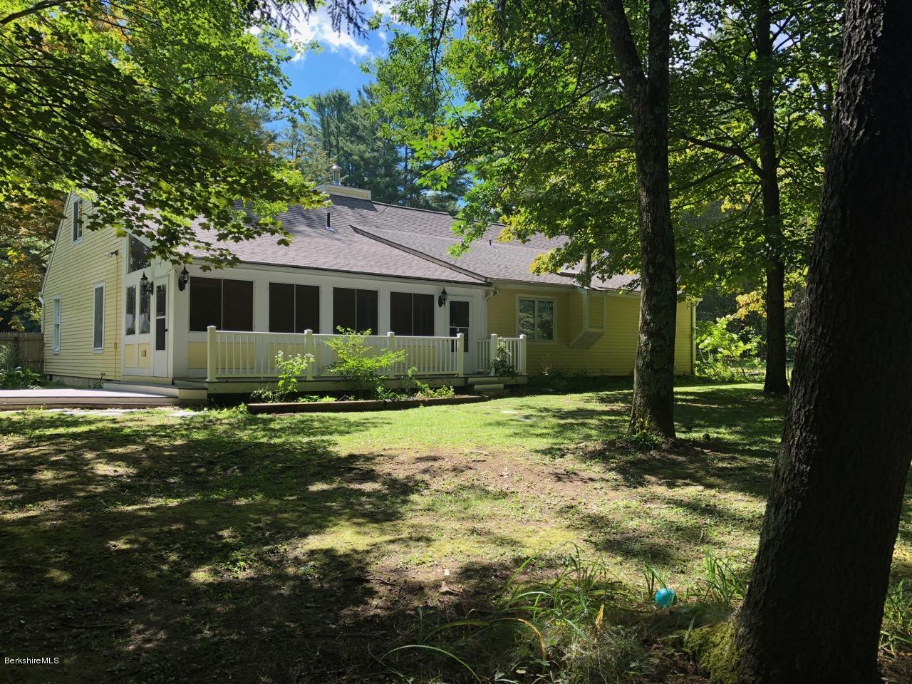 83 Pine Knoll Road Lenox, MA 01240 - Photo 6 of 32 a backyard of a house with yard and outdoor seating