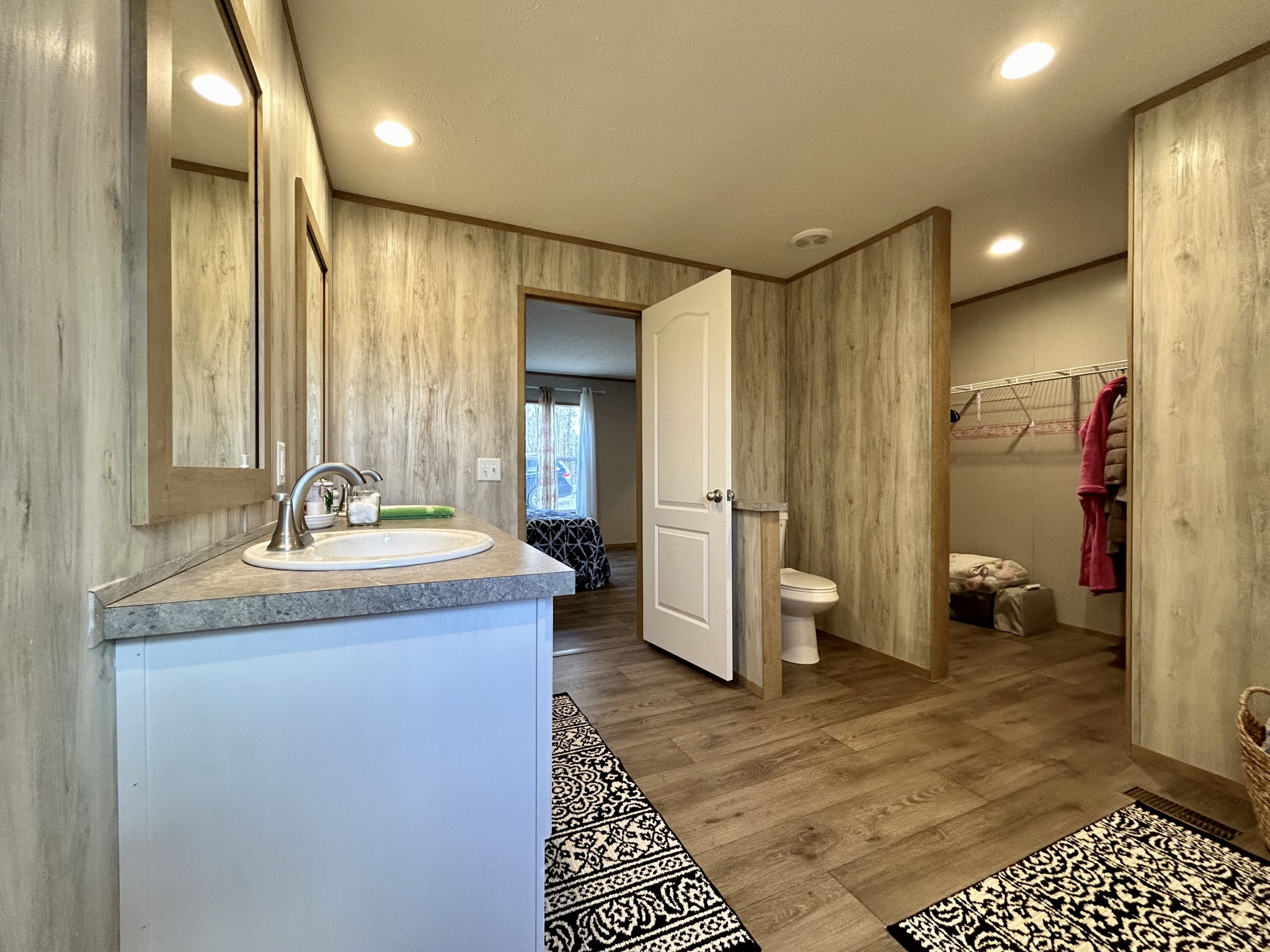 443 Sickler Road Hohenwald, TN 38462 - Photo 21 of 33 a bathroom with a granite countertop sink a toilet a mirror and shower