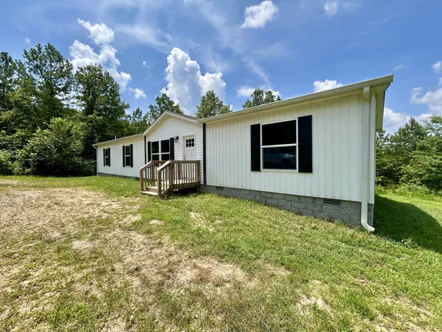 a view of a house with backyard and garden