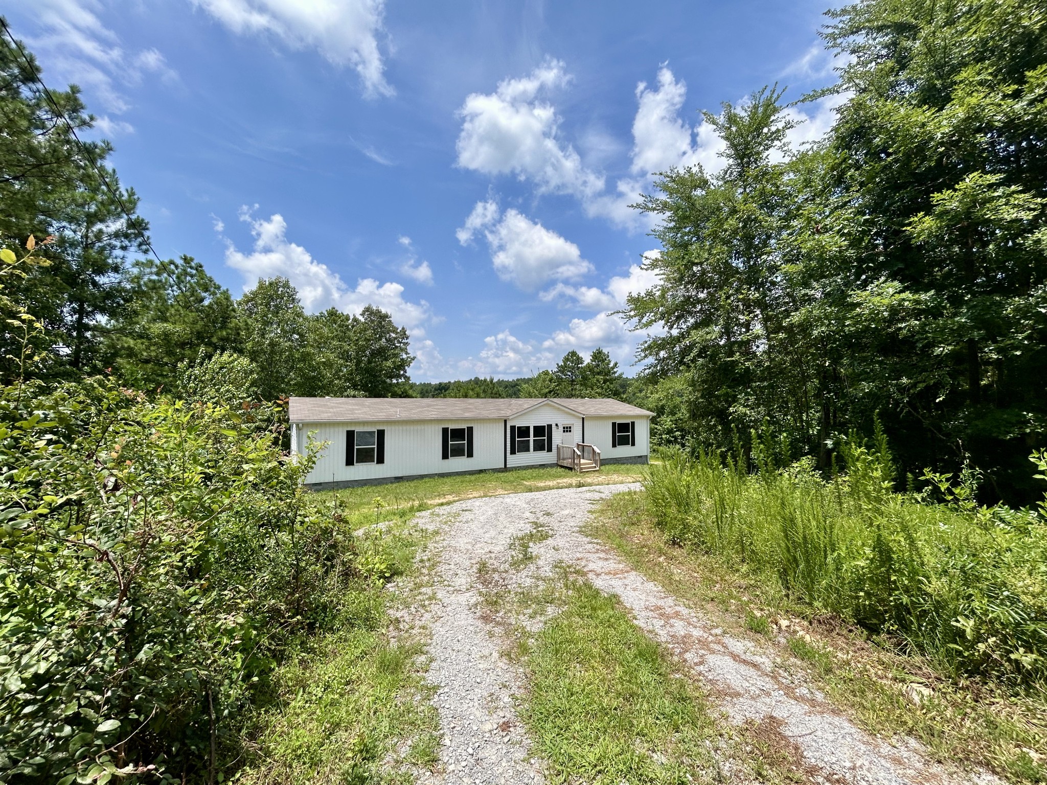 443 Sickler Road Hohenwald, TN 38462 - Photo 32 of 33 a front view of a house with yard and trees