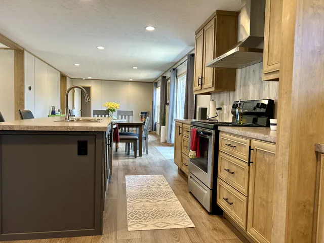 a kitchen with stainless steel appliances granite countertop a stove a sink and a refrigerator