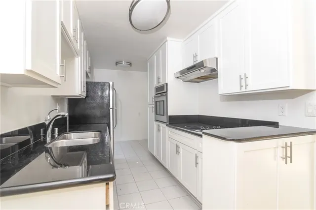 a kitchen with stainless steel appliances granite countertop a sink and a stove