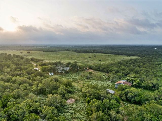 an aerial view of residential houses with outdoor space and trees