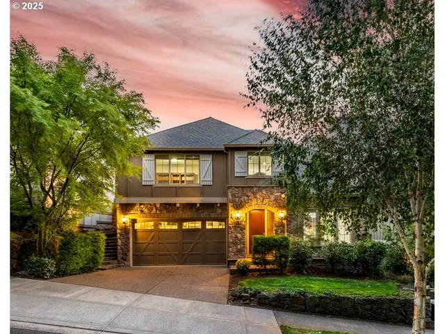 a front view of a house with a yard and trees
