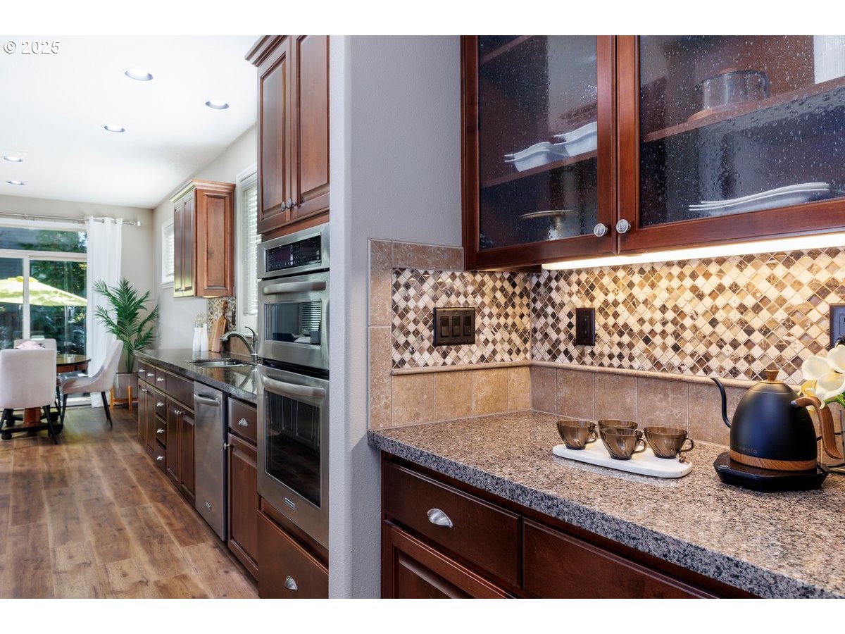 5598 Northwest 135th Avenue Portland, OR 97229 - Photo 12 of 45 a kitchen with stainless steel appliances granite countertop a sink stove and cabinets