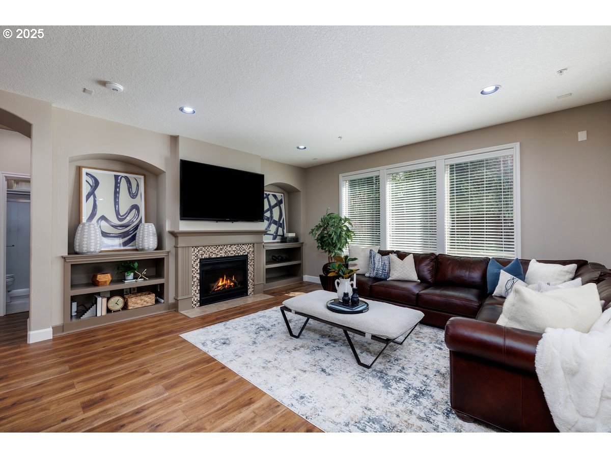 5598 Northwest 135th Avenue Portland, OR 97229 - Photo 20 of 45 a living room with furniture a fireplace and a flat screen tv