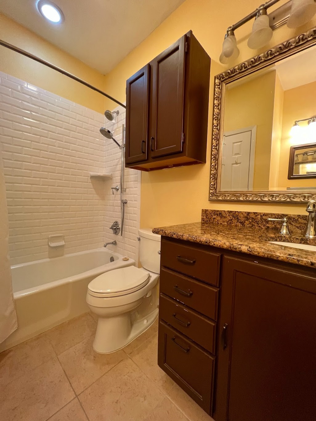 908 Poplar Street, Unit 207 Austin, TX 78705 - Photo 17 of 19 a bathroom with a granite countertop toilet a sink and bathtub