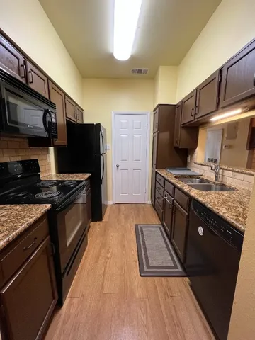 a kitchen with stainless steel appliances granite countertop a stove and a refrigerator