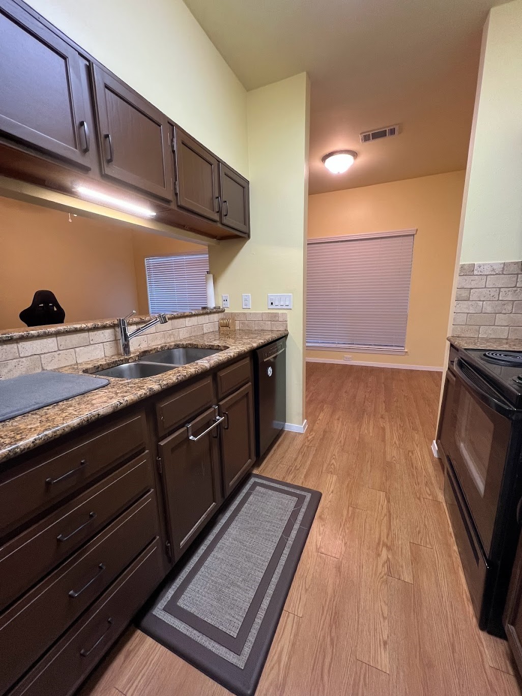 908 Poplar Street, Unit 207 Austin, TX 78705 - Photo 10 of 19 a kitchen with granite countertop stainless steel appliances a sink stove top oven and cabinets