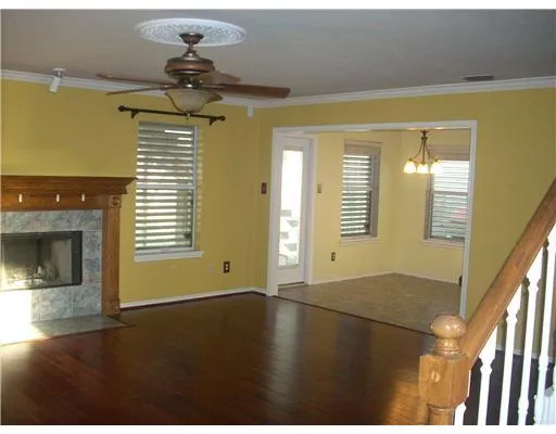 a view of an empty room with a window and fireplace