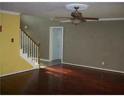 a view of a room with hardwood floor and a ceiling fan