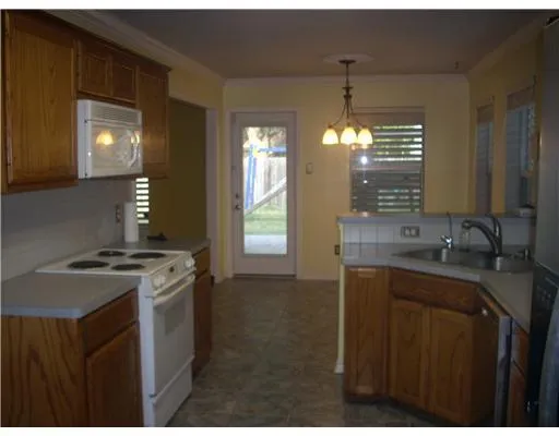 a kitchen that has a sink stove and cabinets