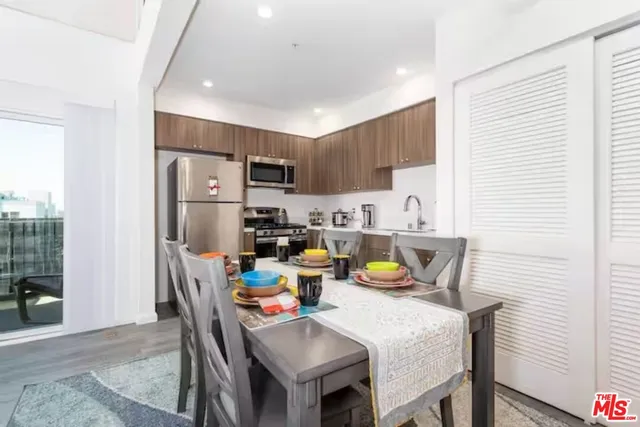 a kitchen with a dining table chairs and refrigerator