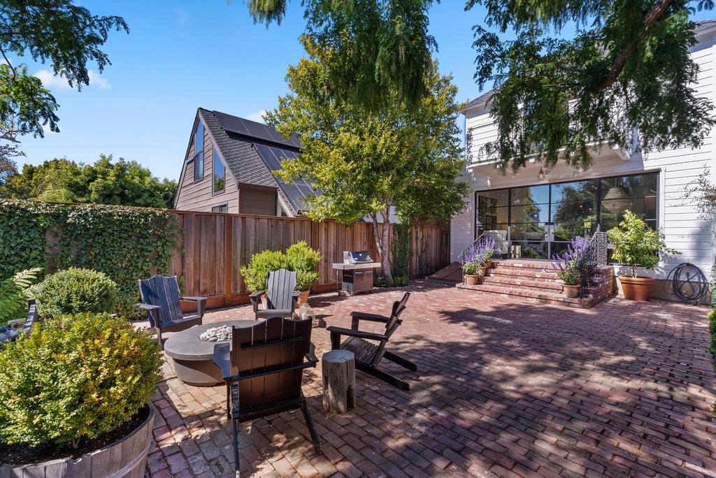 109 Central Avenue Capitola, CA 95010 - Photo 58 of 79 a view of a patio with table and chairs potted plants and a large tree