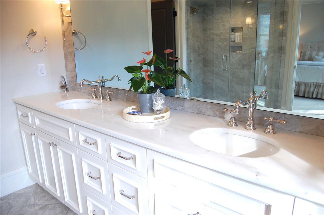 2620 Davis Street Raleigh, NC 27608 - Photo 21 of 28 Dual vanities with marble tops and custom cabinetry. Mirror has a tv installed in the center, which is not visible unless turned on. Speakers are installed in master bath. Master Bath