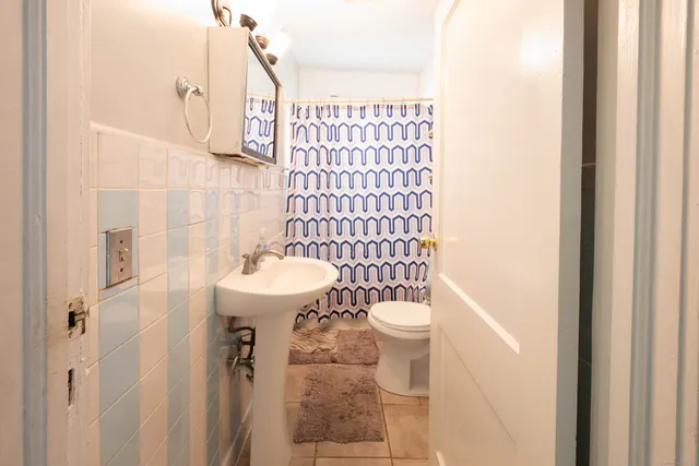 a bathroom with a sink a toilet and shower curtain