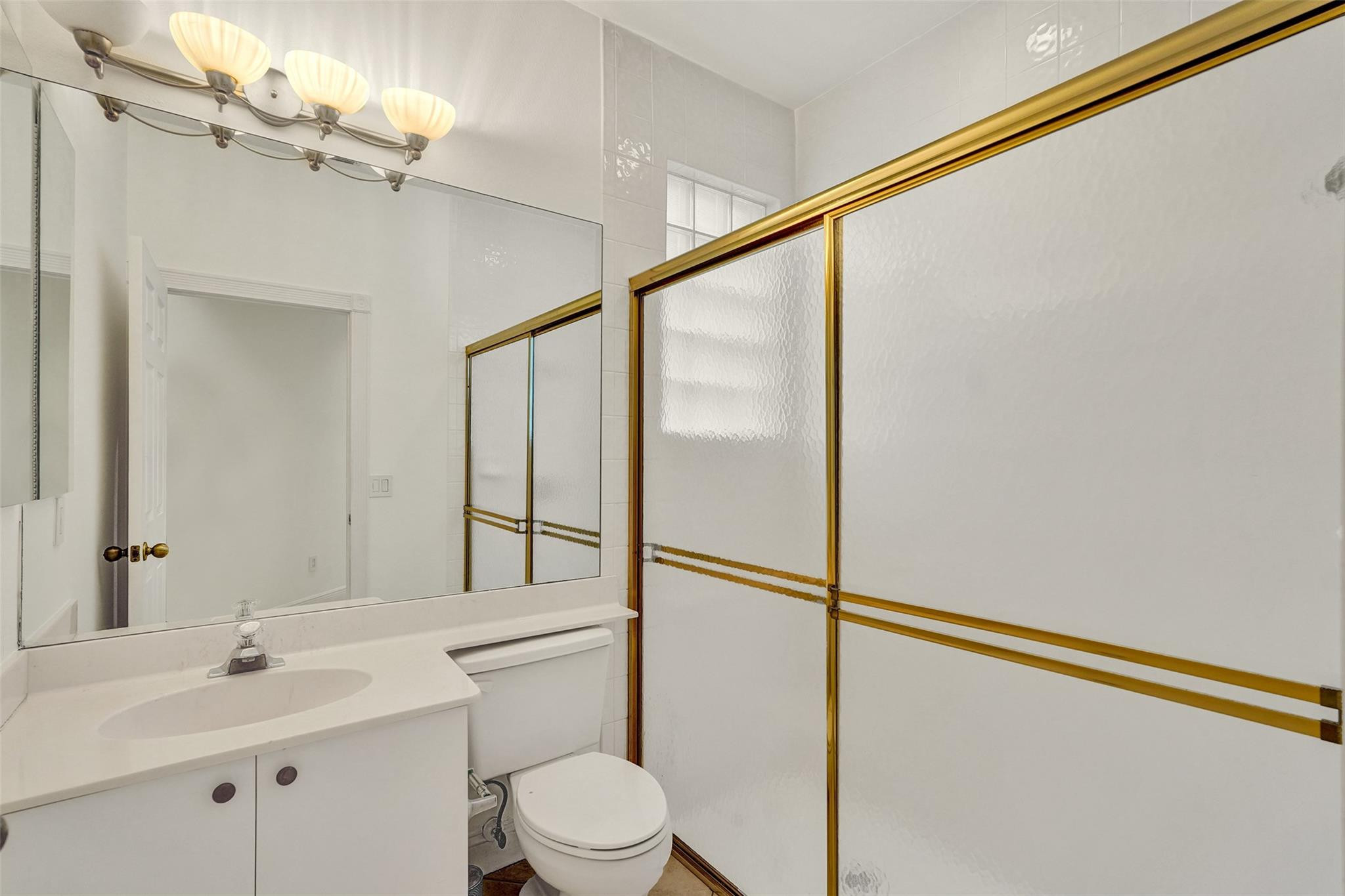 10902 Tamoron Lane Boca Raton, FL 33498 - Photo 20 of 66 a bathroom with a sink vanity mirror and toilet