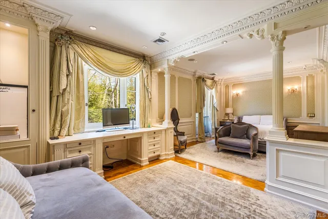 a bedroom with furniture and a large window