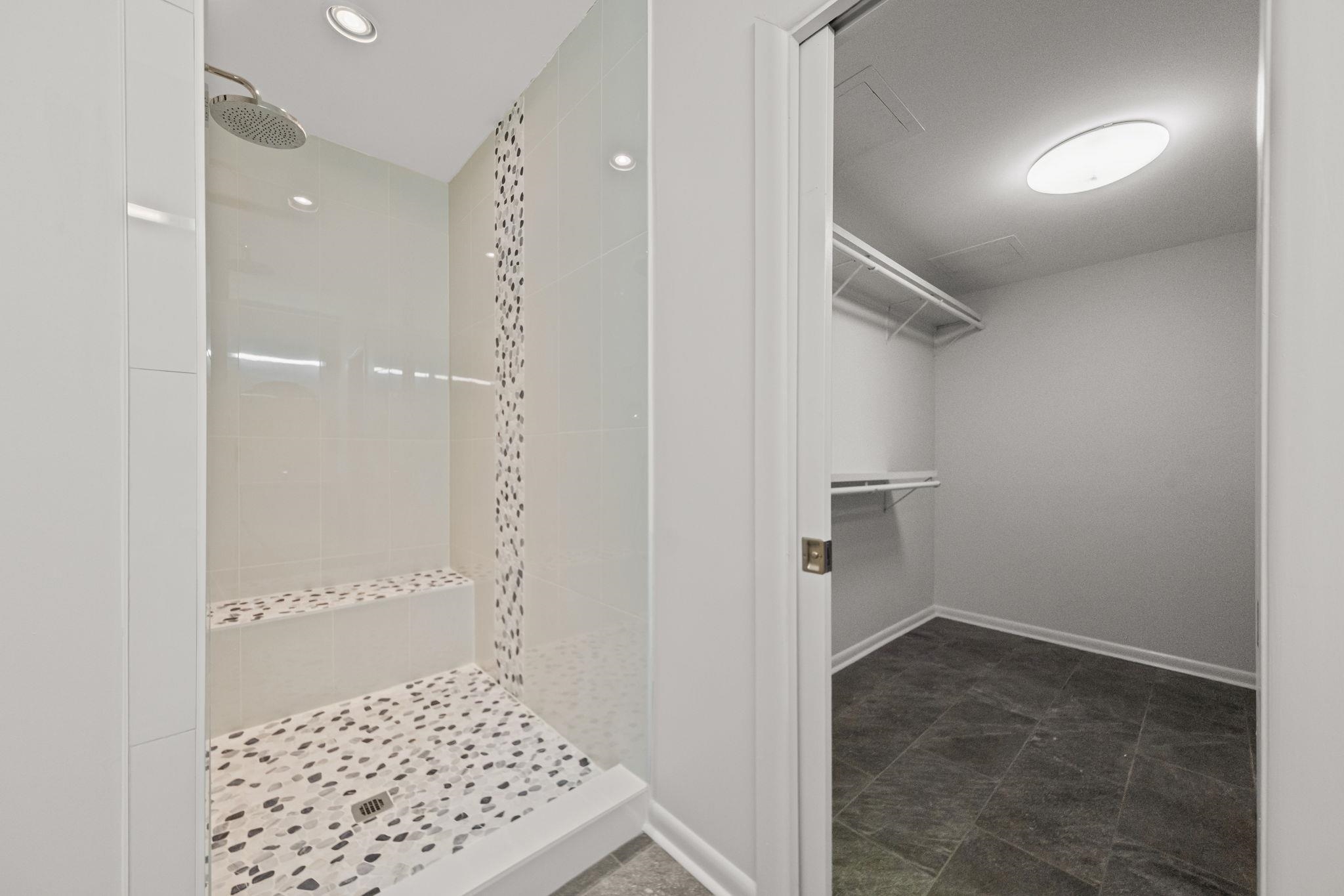 448 Tennessee Street Memphis, TN 38103 - Photo 21 of 39 Walk-in shower with a built-in bench, pebbled flooring, rain shower head, recessed lighting, and an adjacent closet with wire shelving