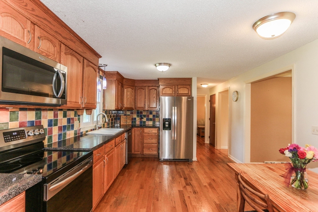 66 Metacomet Road Longmeadow, MA 01106 - Photo 8 of 40 a kitchen with stainless steel appliances kitchen island granite countertop a stove a sink and a refrigerator