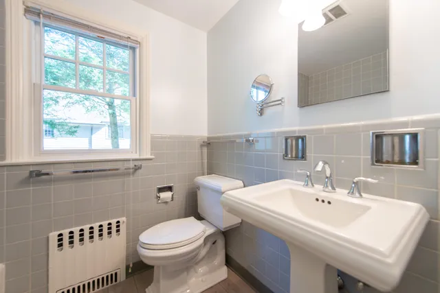 a bathroom with a sink a toilet and a mirror