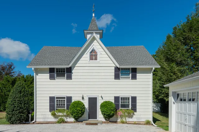a front view of a house with potted plants