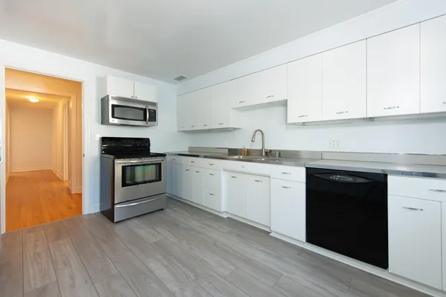 a kitchen with granite countertop white cabinets and white appliances
