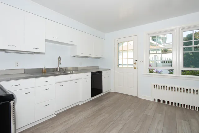 a kitchen with granite countertop white cabinets and white appliances